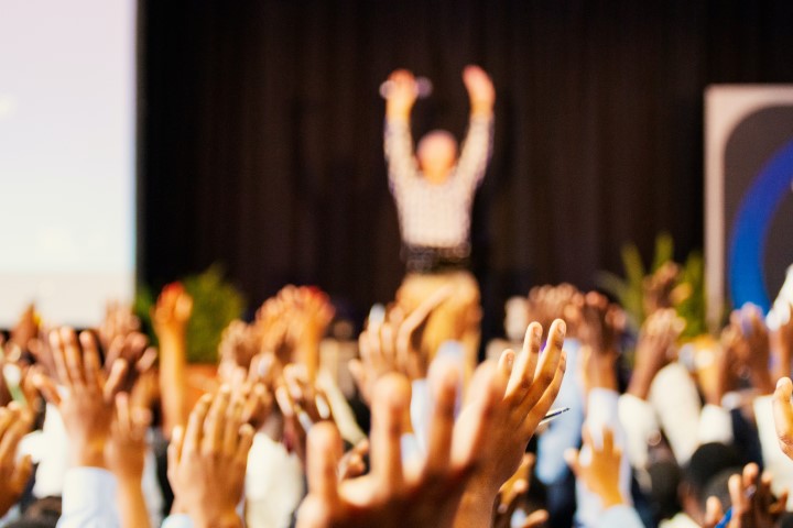 Conference with hands raised in the air : Annual General Meeting