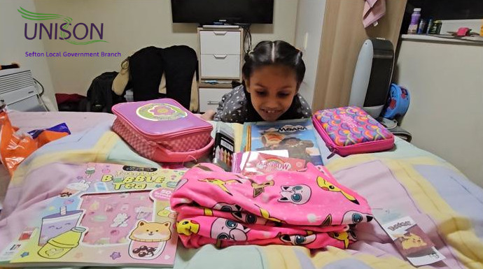 Child surrounded by presents at Christmas thanks to Sefton UNISON